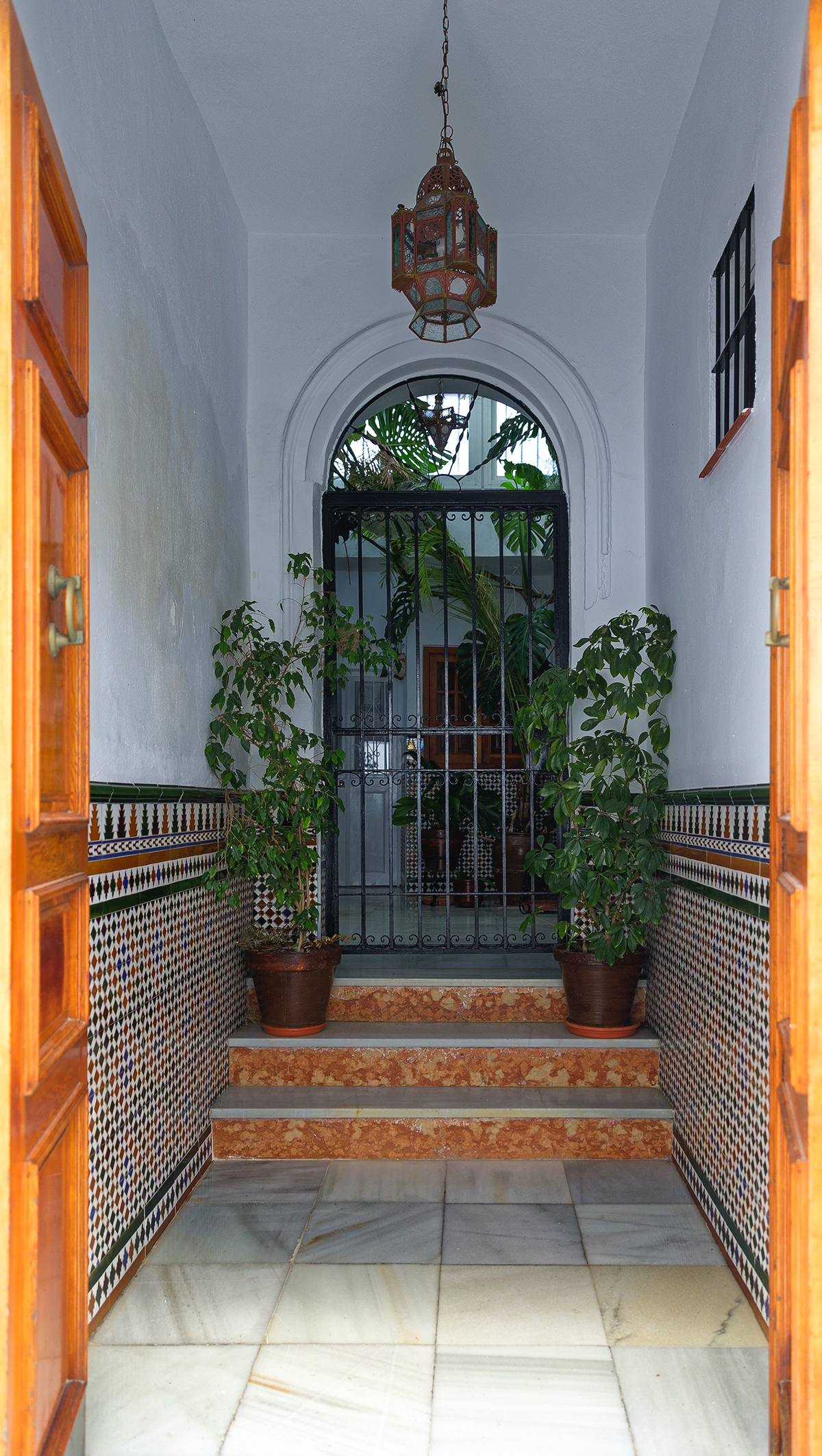 Arcos de la Frontera - Entrée de maison typique : carrelage, fer forgé et fleurs